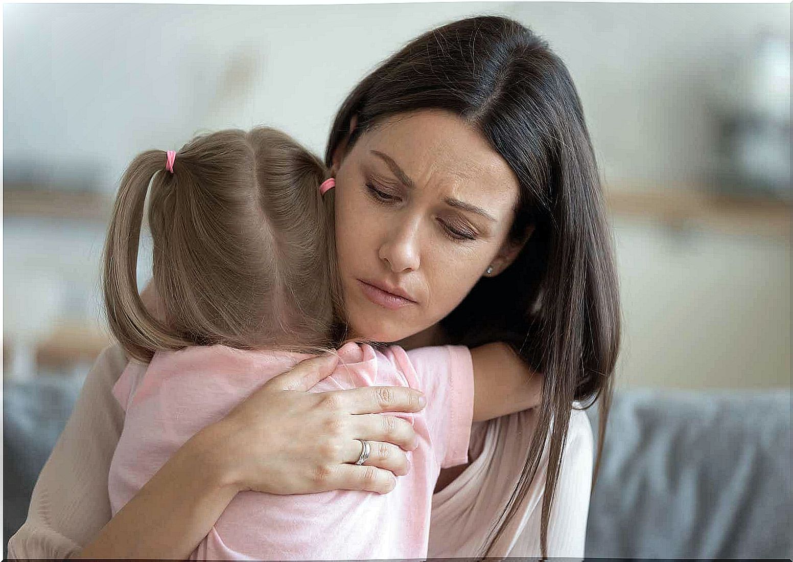 A mother comforting her young daughter with a hug