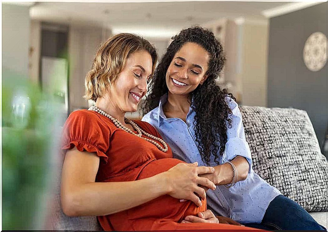 A woman touching her partner's pregnant belly