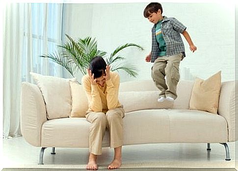 frustrated mother with boy jumping on sofa