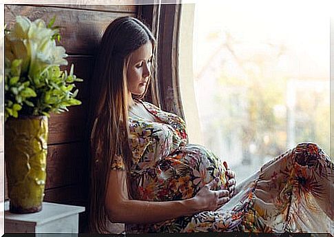 pregnant woman in dress holding on to her belly