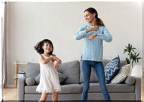 mother and daughter dancing in living room