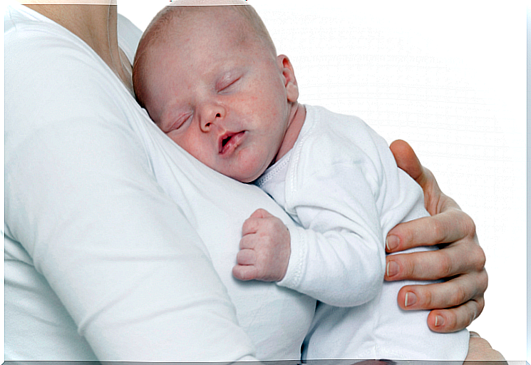 baby sleeping in his mother's arms