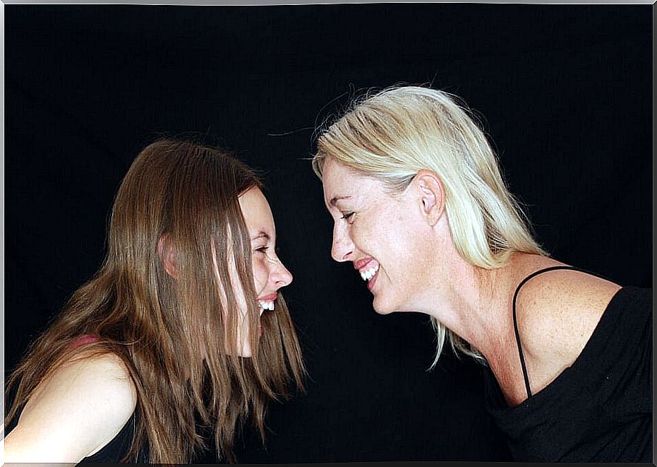 woman and girl laughing at each other