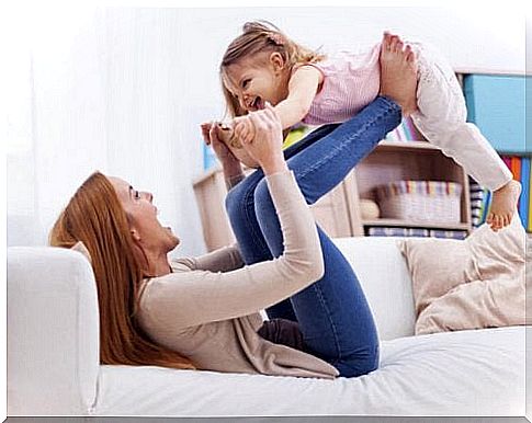 woman lifting girl with her legs on sofa