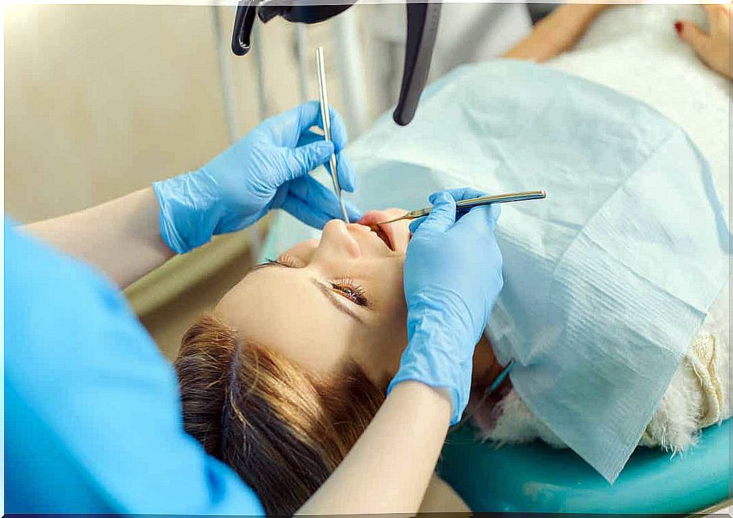 A dentist working on a woman's teeth