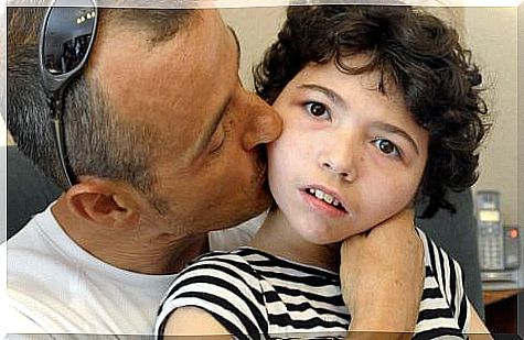 father kissing his child on the cheek