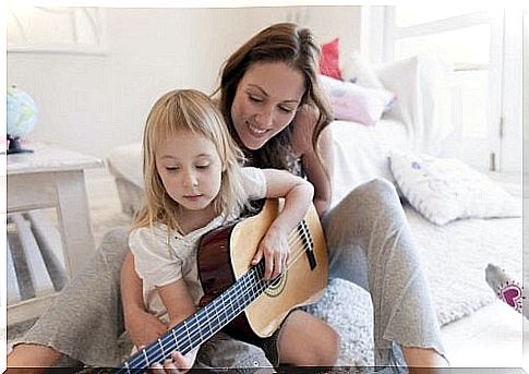 mother and daughter practicing a guitar