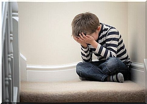 boy sitting on stairs with head in his hands