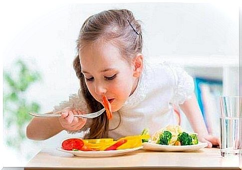 little girl eating vegetables