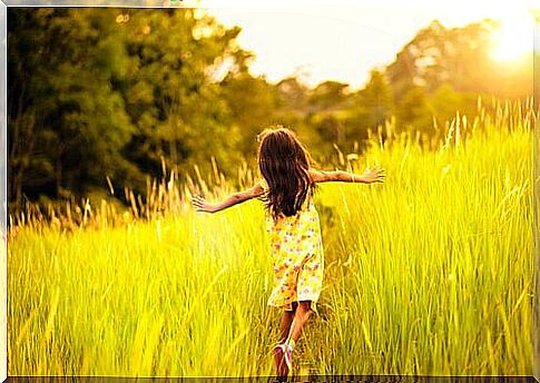 Little girl running through a meadow