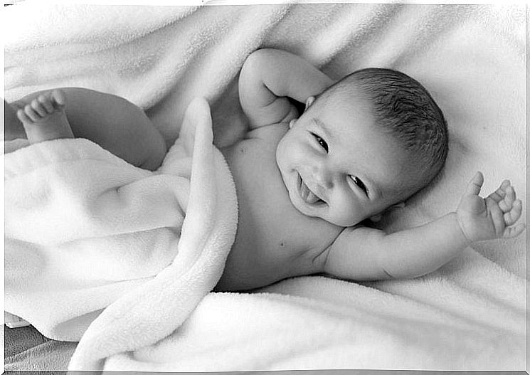 happy baby lying in a bed