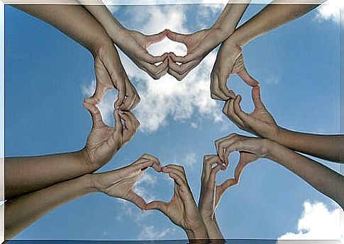 hands forming hearts against the sky