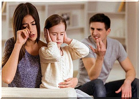 child holding his ears while his parents discuss