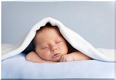 sleeping baby hugs his teddy bear