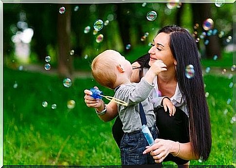 mother and son playing with soap bubbles 