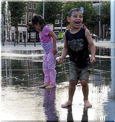 siblings playing in fountains