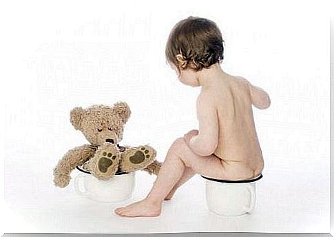 child and teddy bear sitting on potty