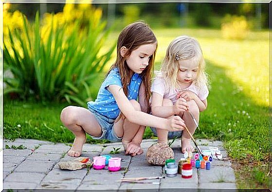 little girls painting on tiles