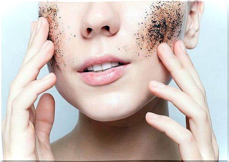 Woman exfoliates skin with coffee grounds.