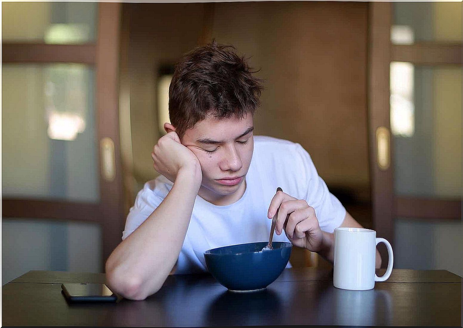 A teenager who is tired at breakfast