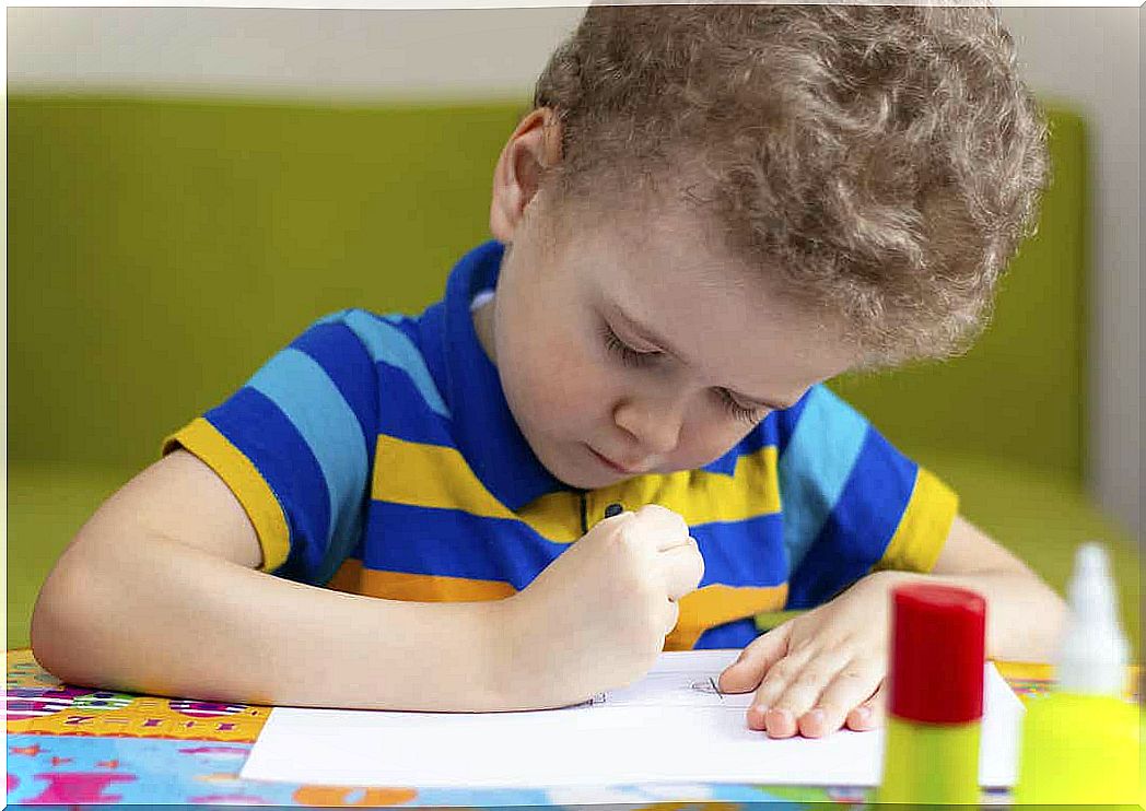 A little boy is making a drawing