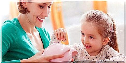 girl putting money in piggy bank