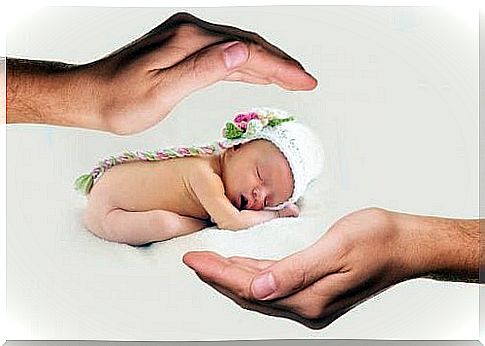 Parents hold newborn baby in a hat