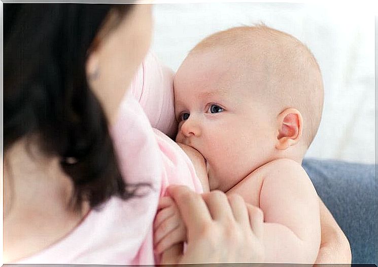 baby breastfeeds with his mother