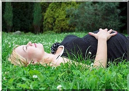 A women is lying on the grass