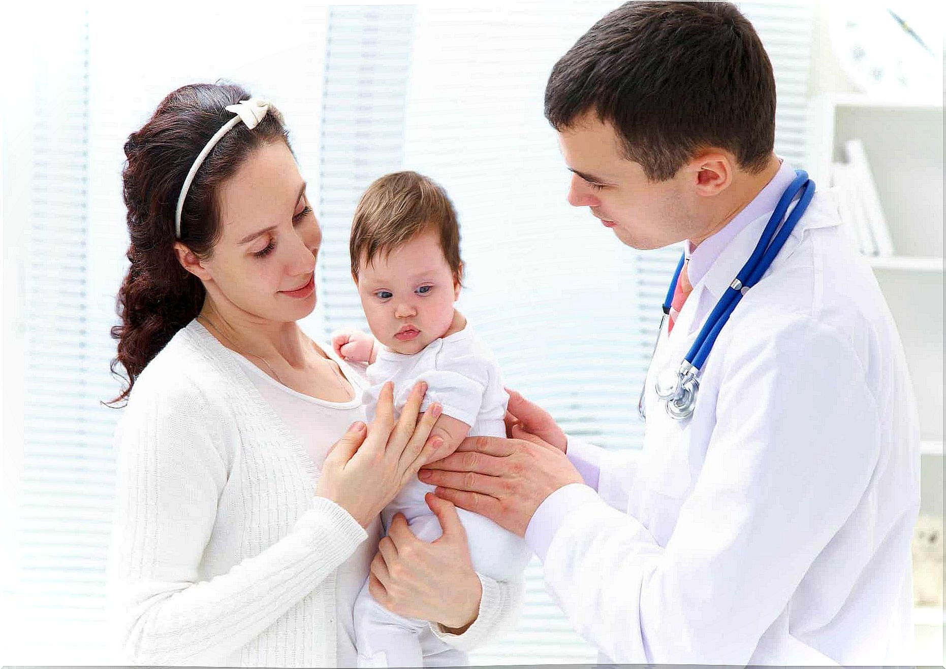 A mother handing over her baby to a pediatrician