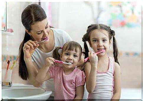 mother and daughters brushing teeth