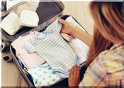 mother packing suitcase with baby clothes